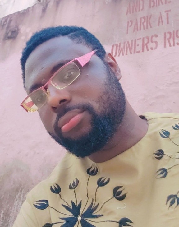 Selfie of Uche Okochi wearing pink and gold glasses.